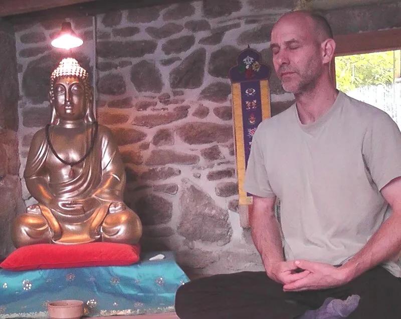 Colin meditating in a stone meditation room in France