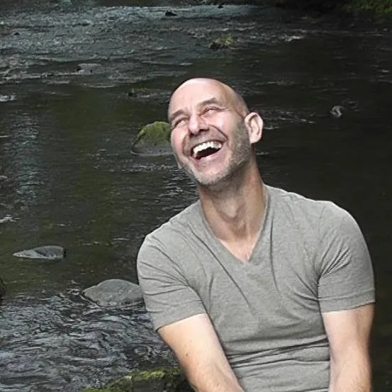 Colin Ellis laughing by a river